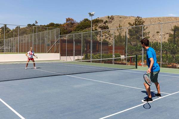 Zwei Spieler spielen Tennis auf einem Tennisplatz am Princess Andriana Resort & Spa.