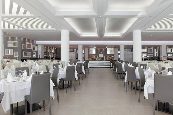 Restaurant-Innenbereich des Princess Andriana Resort & Spa mit leeren Tischen und Stühlen.
