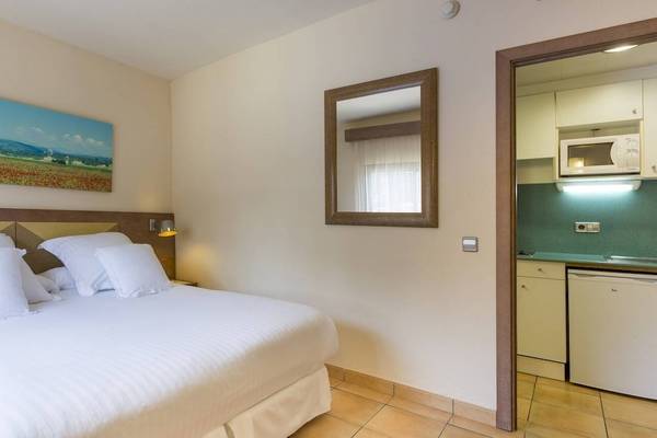 Hotelzimmer im Occidental Playa de Palma mit Bett, Spiegel und Kunstwerk an der Wand.