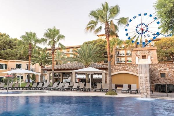 Außenpool des Occidental Playa de Palma Hotels mit Sonnenliegen, Schirmen und einer Fahrattraktion im Hintergrund.