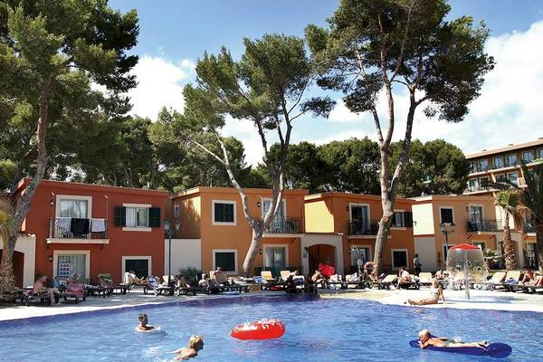 Gäste entspannen sich im Swimmingpool und auf Sonnenliegen im Occidental Playa de Palma Hotel.