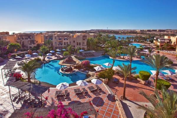 Aussenbereich des Steigenberger Coraya Beach Hotels mit Swimmingpool und Sonnenliegen.