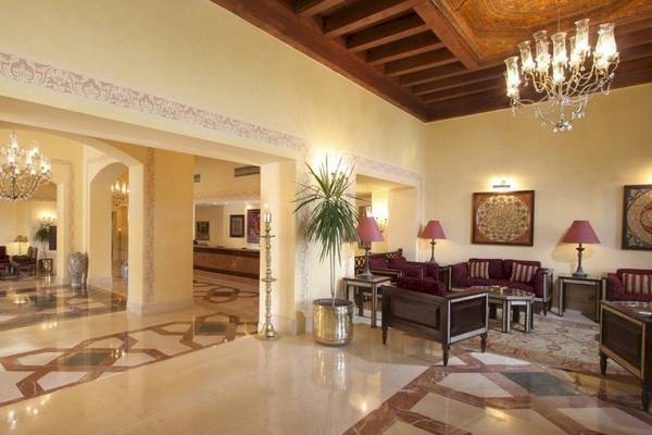 Lobby des Steigenberger Coraya Beach Hotels mit gemusterten Böden, Möbeln und Kronleuchtern.