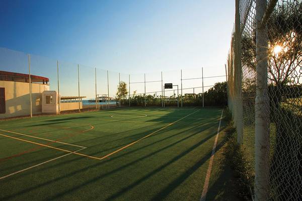 Außen-Tennisplatz im Cornelia Diamond Golf Resort & Spa mit umzäuntem Areal und Blick auf den See.