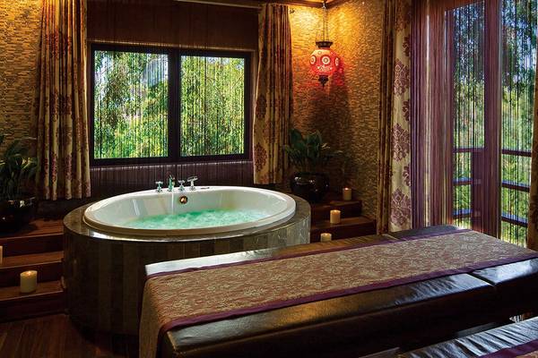 Behandlungsraum im Cornelia Diamond Golf Resort & Spa mit Badewanne und Fenstern.