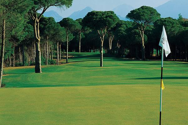 Golfplatz im Cornelia Diamond Golf Resort & Spa mit grünen Fairways und Bäumen.