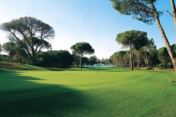 Golfplatz im Cornelia Diamond Golf Resort & Spa mit grünen Rasen und Bäumen.