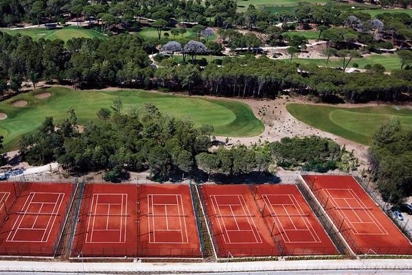 Luftaufnahme der Tennisplätze im Cornelia Diamond Golf Resort & Spa mit umgebender Natur