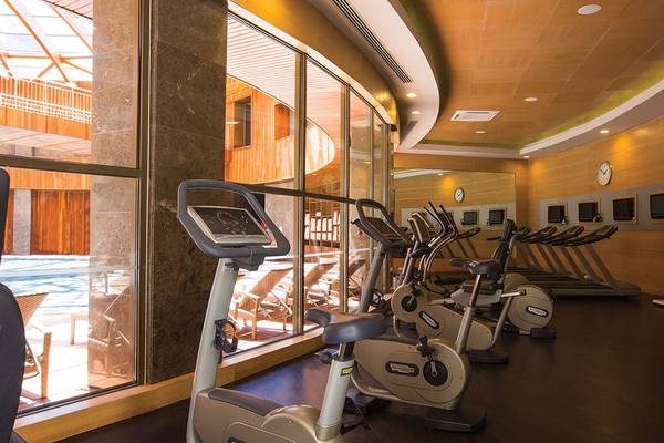 Fitness Center im Cornelia Diamond Golf Resort & Spa mit Blick auf den Pool.