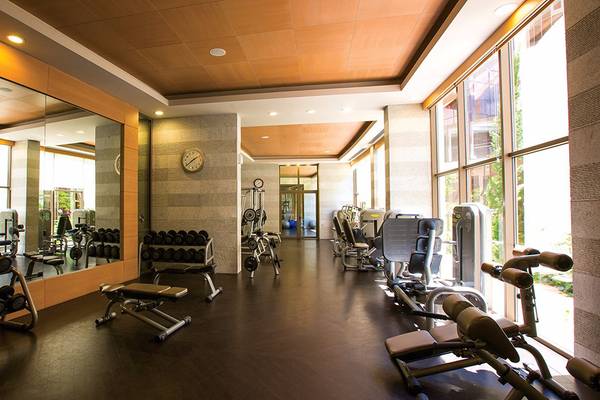 Innenansicht des Fitnesscenters im Cornelia Diamond Golf Resort & Spa mit vielen Geräten und Spiegeln.