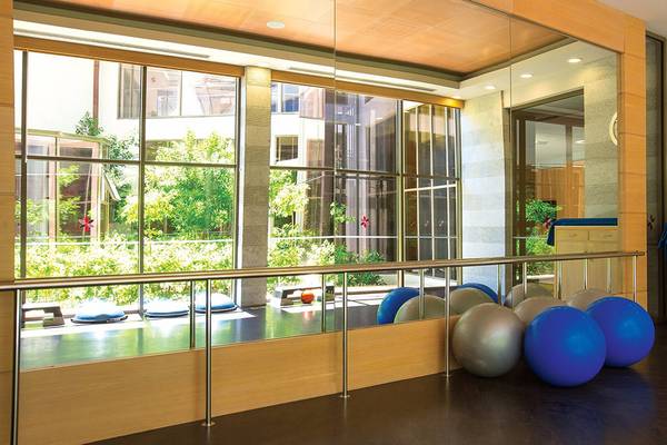 Fitnessbereich im Cornelia Diamond Golf Resort & Spa mit großen Fenstern und Fitnessgeräten.