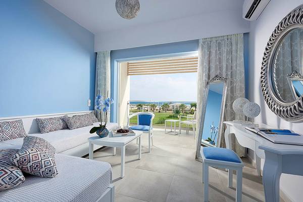 Schlafzimmer im Mythos Palace Resort & Spa mit Blick auf das Meer und den Garten.