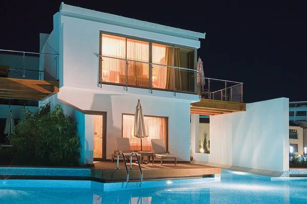 Cornelia Diamond Golf Resort & Spa Villa bei Nacht mit Swimmingpool und Terrassenmöbeln