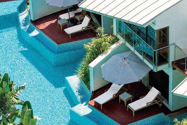 Pool-Ansicht des Cornelia Diamond Golf Resort & Spa mit Lounges und Sonnenschirmen.