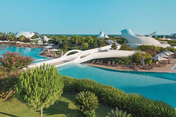 Luftaufnahme des Cornelia Diamond Golf Resort & Spa mit Schwimmbad, Wasserrutsche und moderner Architektur