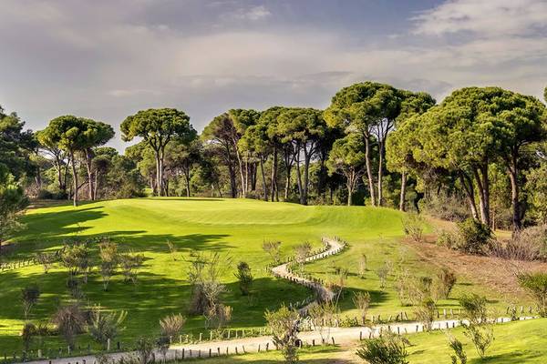 Golfplatz im Cornelia Diamond Golf Resort & Spa mit umliegenden Bäumen und einem gepflegten Weg.
