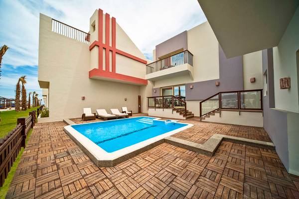 Swimmingpool vor dem Sunrise Crystal Bay Resort mit Lounge-Sesseln und einer Treppe.