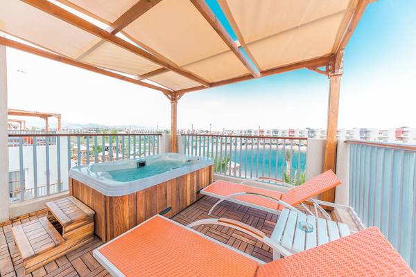 Ein Balkon mit einem Whirlpool und Blick auf das Meer im Sunrise Crystal Bay Resort.