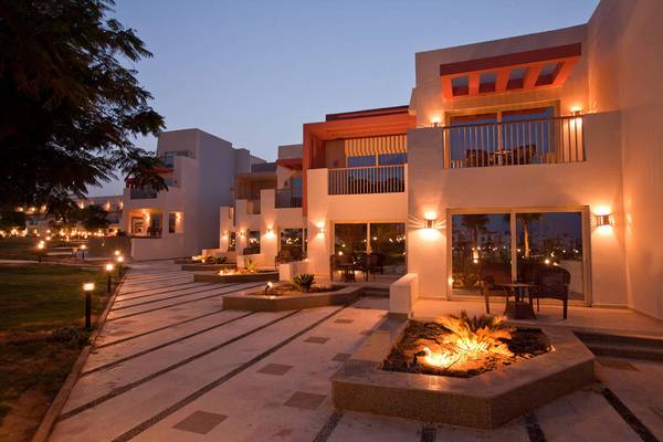 Außenansicht des Sunrise Crystal Bay Resorts bei Nacht mit illuminierten Gebäuden, brennendem Feuer und illuminierten Wegen.