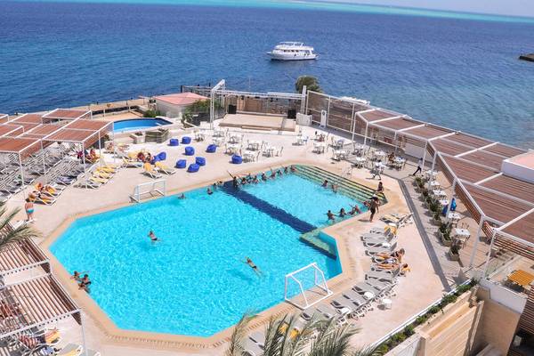 Luftaufnahme des Pools im Sunrise Crystal Bay Resort mit Gästen und einem Boot im Hintergrund.