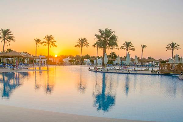 Sonnenuntergang am Pool des Sunrise Crystal Bay Resorts mit Palmen und Sonnenliegen