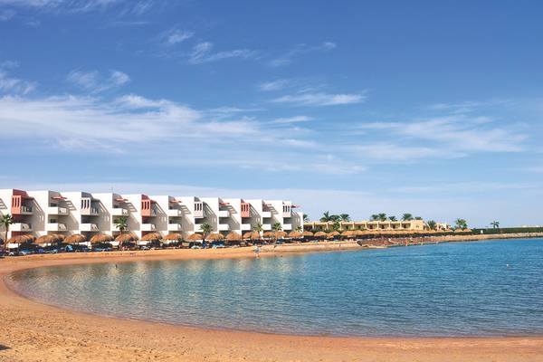 Strandansicht des Sunrise Crystal Bay Resorts mit weißen Gebäuden und blauem Wasser.