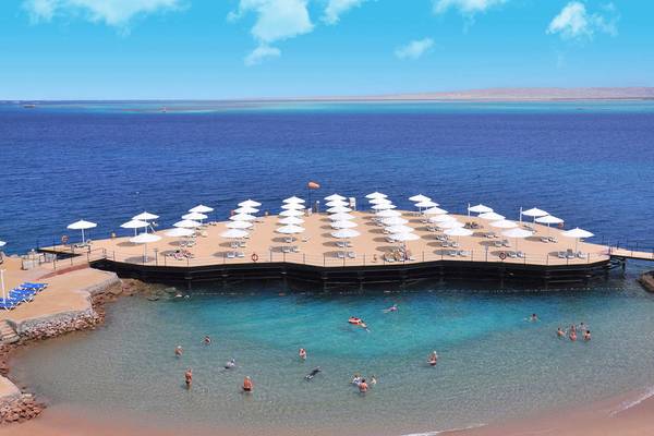 Luftaufnahme des Sunrise Crystal Bay Resorts mit vielen Sonnenschirmen und Gästen im Wasser.
