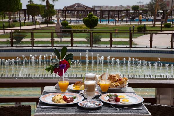 Frühstücksbuffet mit Blick auf einen Brunnen im Sunrise Crystal Bay Resort.