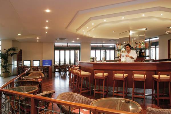 Barbereich im Atlantica Mikri Poli Rhodes Hotel mit Barkeeper und Holzmöbeln.