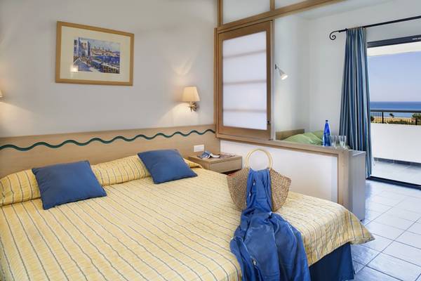Hotelzimmer mit Meerblick im Atlantica Mikri Poli Hotel auf Rhodos, mit einem Bett, Balkon und Blick auf das Meer.