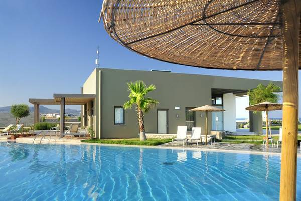 Außenbereich des Atlantica Mikri Poli Rhodes Hotels mit Pool und Sonnenschirmen.