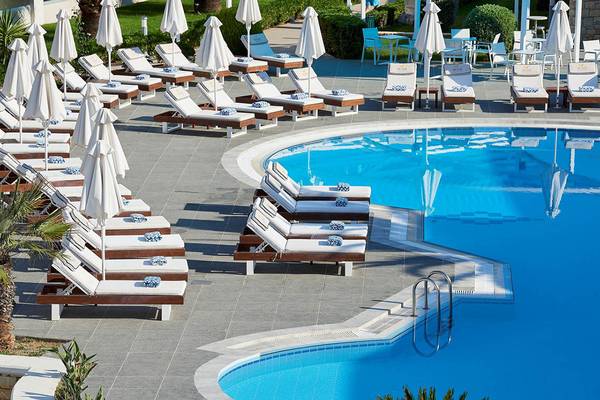 Mythos Palace Resort & Spa Poolbereich mit Liegen und Sonnenschirmen