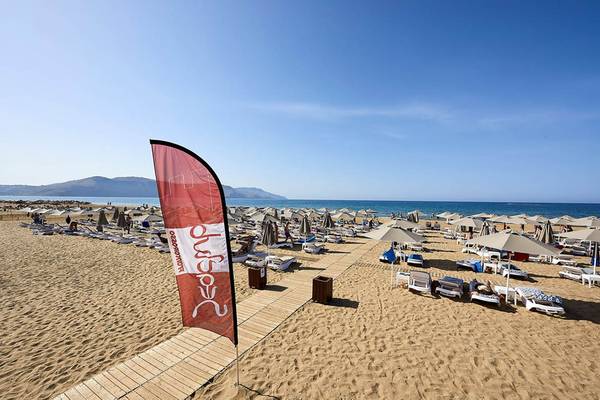 Mythos Palace Resort & Spa Strand mit vielen Liegestühlen und Sonnenschirmen