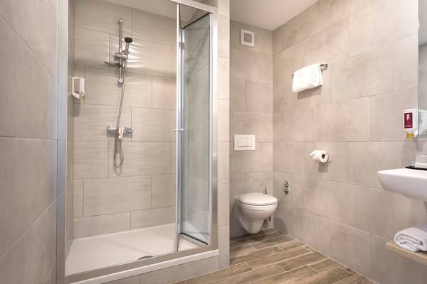 Badezimmer im Remisens Hotel Epidaurus mit Dusche, Toilette und Waschbecken.