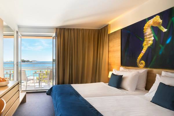 Zimmer im Remisens Hotel Epidaurus mit Blick auf das Meer und einen Balkon.