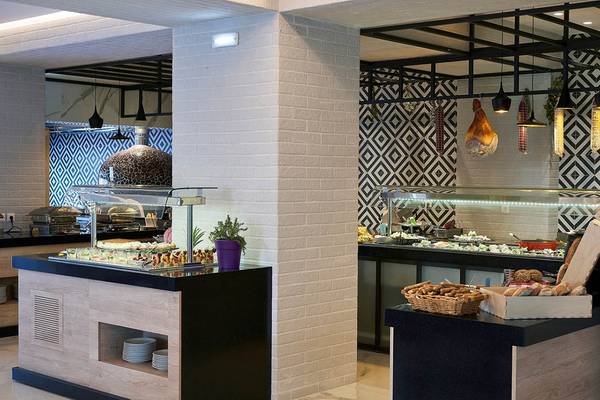 Innenansicht des Restaurants im Mythos Palace Resort & Spa mit Speisen auf Buffets und dekorativen Wandmustern.