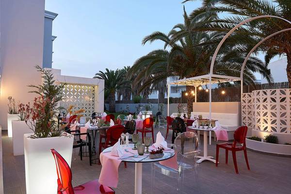 Außenbereich des Mythos Palace Resort & Spa mit Tisch, Stühlen und Pflanzen.
