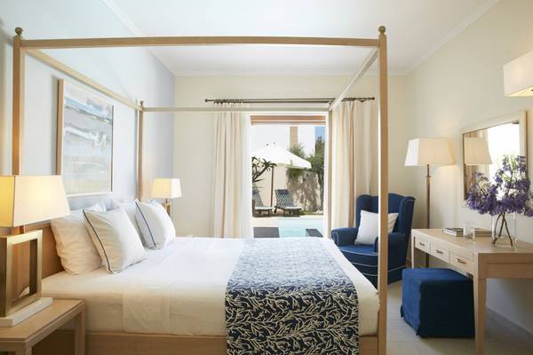 Schlafzimmer im Lindian Village Beach Resort Rhodes mit einem Himmelbett, Poolblick und modernen Möbeln.