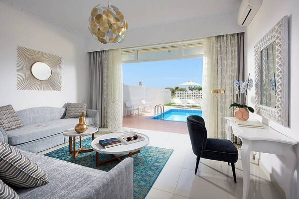Wohnzimmer des Mythos Palace Resort & Spa mit Poolblick.