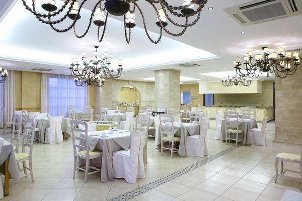 Lindian Village Beach Resort Rhodes Hotel Innenrestaurant mit gedeckten Tischen und Kronleuchtern.
