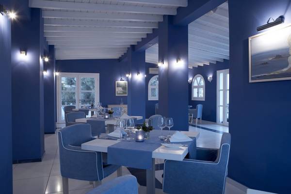 Innenansicht des Restaurants im Lindian Village Beach Resort auf Rhodos, mit blauen Wänden und Möbeln.