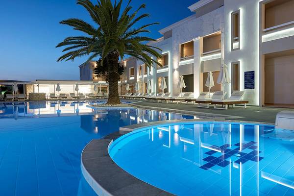 Mythos Palace Resort & Spa Pool bei Nacht mit Palme und Lounge-Sesseln
