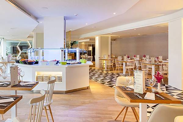 Innenansicht des TigOTAN Lovers & Friends Restaurants mit gepflegten Tischen und Buffet.