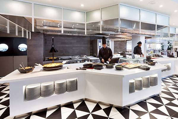 Restaurant-Innenbereich des Hotels Tigotan Lovers & Friends mit schwarzen und weißen Bodenfliesen und weißen Tischen.