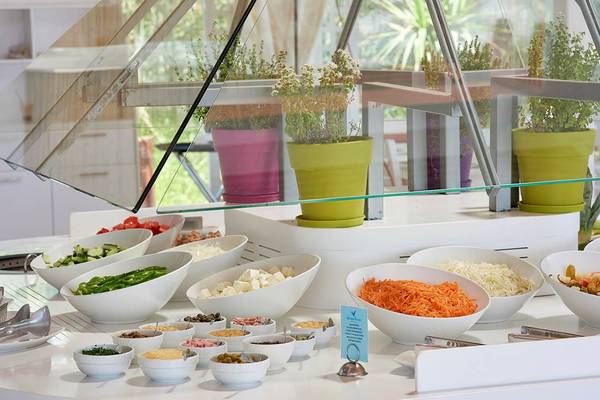 Buffet-Tisch im Mythos Palace Resort & Spa mit verschiedenen Gerichten und Pflanzen in Töpfen.