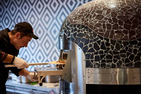 Koch bereitet Pizza im Mythos Palace Resort & Spa im Steinofen zu