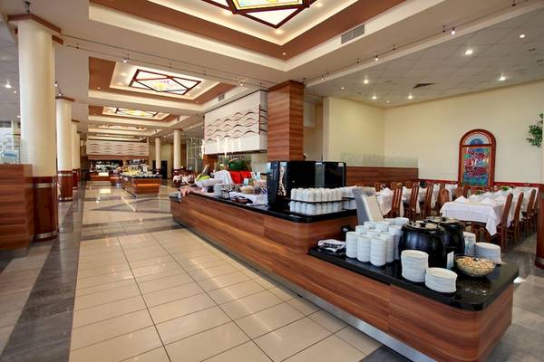 Innenbereich des DIT Evrika Beach Club Hotels mit Buffet und Sitzbereichen.