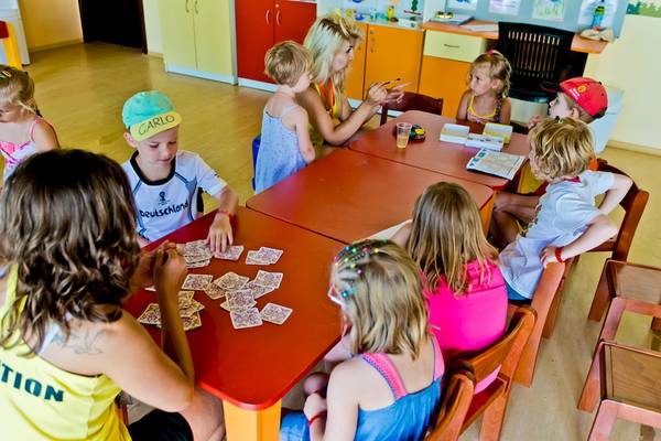 Kinder spielen Karten in einem Klassenzimmer im DIT Evrika Beach Club Hotel.