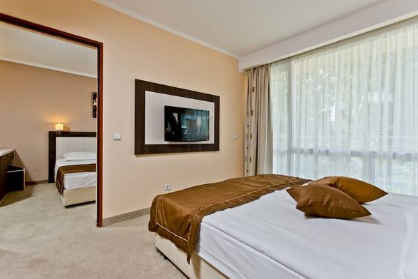 Hotelzimmer im DIT Evrika Beach Club mit Fernseher, Betten und Fenstern.
