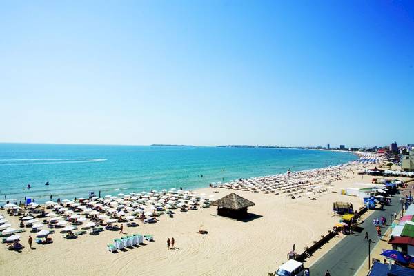 Luftaufnahme des DIT Evrika Beach Clubs am Strand mit vielen Sonnenschirmen und Gästen.